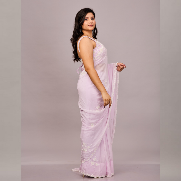 soft pastel pink saree with delicate floral embroidery and a scalloped border
