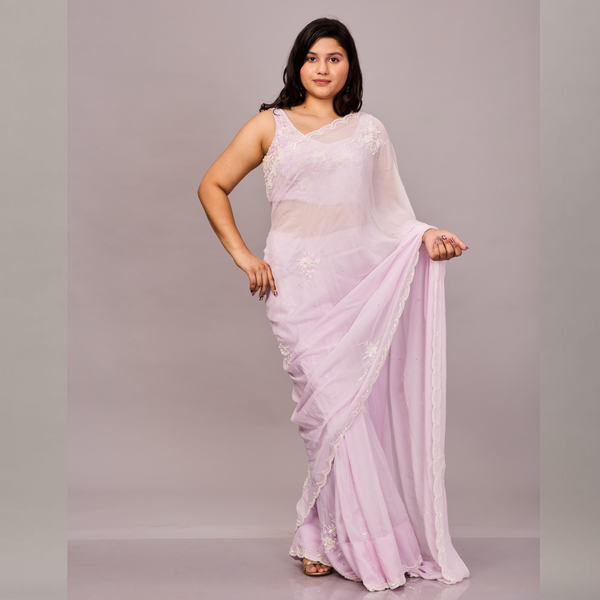 soft pastel pink saree with delicate floral embroidery and a scalloped border