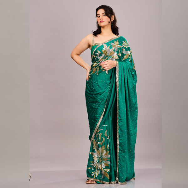 Emerald green saree adorned with gold and silver floral embroidery and a shimmering sequin border.