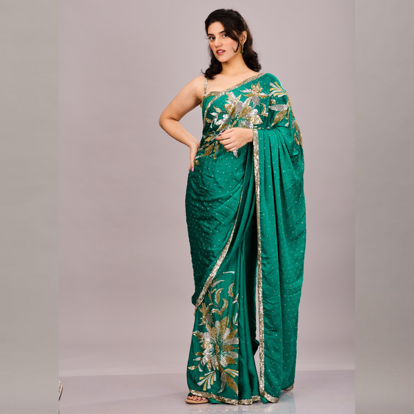 Emerald green saree adorned with gold and silver floral embroidery and a shimmering sequin border.