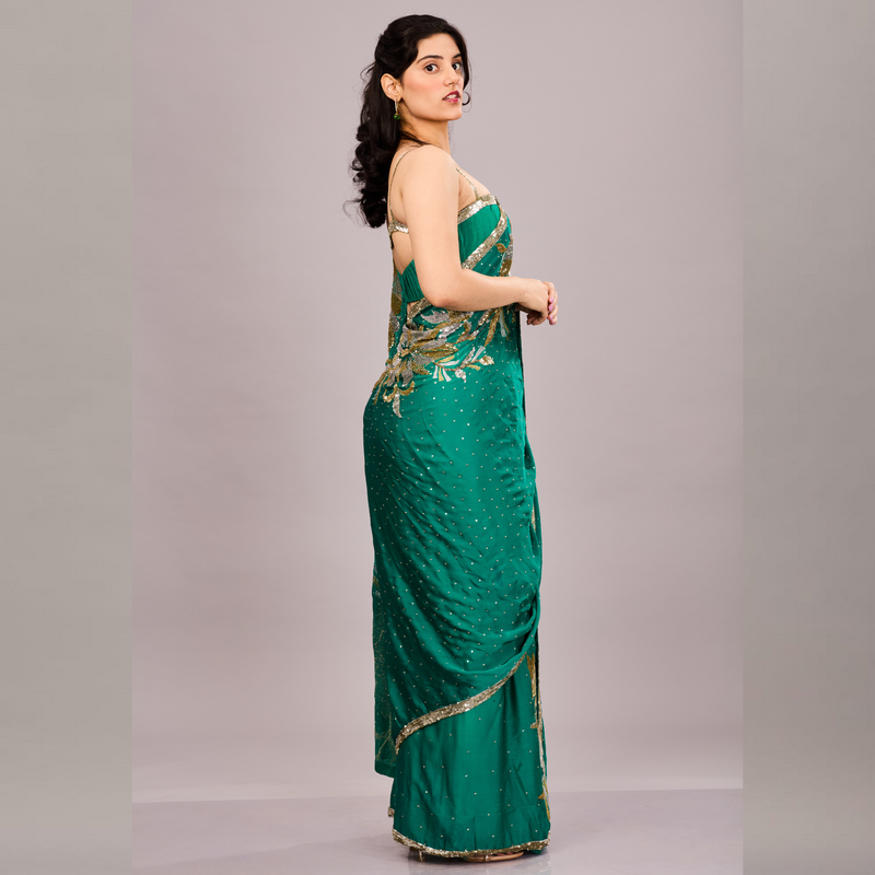 Emerald green saree adorned with gold and silver floral embroidery and a shimmering sequin border. XS Emerald green saree adorned with gold and silver floral embroidery and a shimmering sequin border. XS