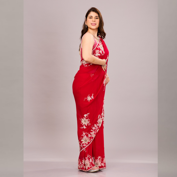 A elegant red saree with intricate silver floral embroidery and a sheer, embroidered pallu