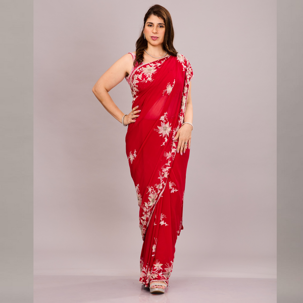 A elegant red saree with intricate silver floral embroidery and a sheer, embroidered pallu