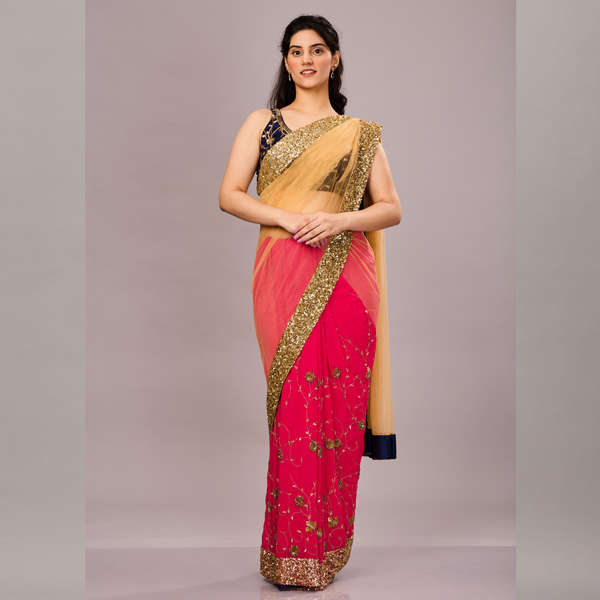 A vibrant pink and beige saree with gold sequin border, floral embroidery, and a contrasting navy blue blouse