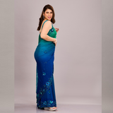 A vibrant green and blue embroidered saree with floral embellishments and sheer fabric