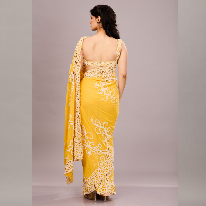 A vibrant yellow saree with intricate white embroidery and lace detailing