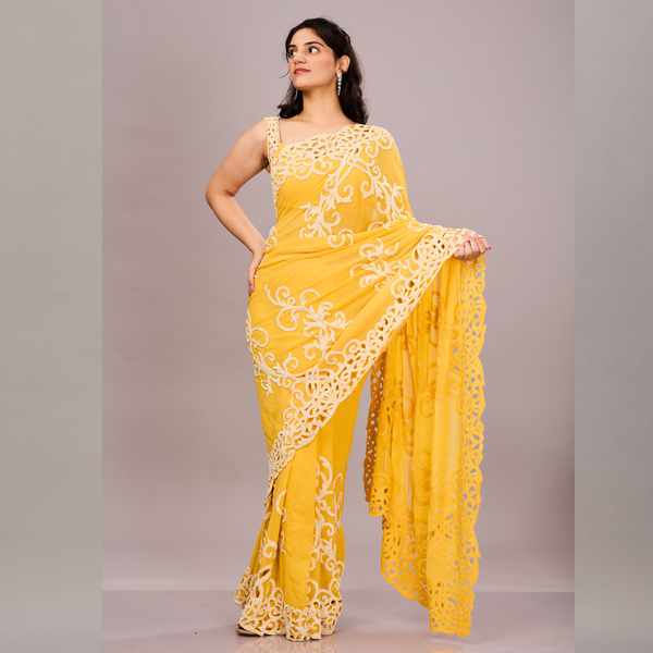 A vibrant yellow saree with intricate white embroidery and lace detailing