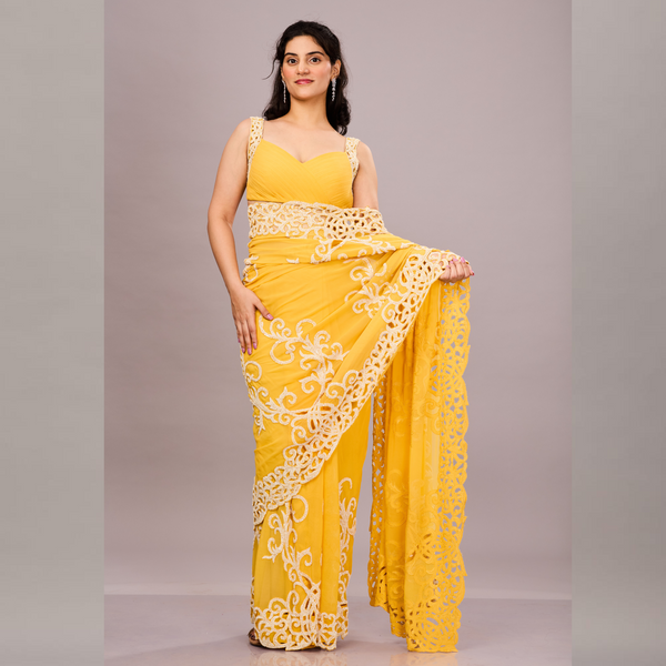 A vibrant yellow saree with intricate white embroidery and lace detailing