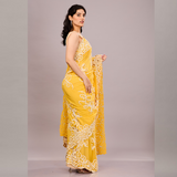 A vibrant yellow saree with intricate white embroidery and lace detailing