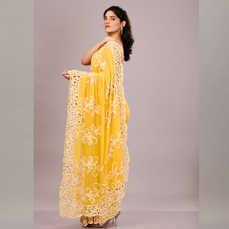 A vibrant yellow saree with intricate white embroidery and lace detailing