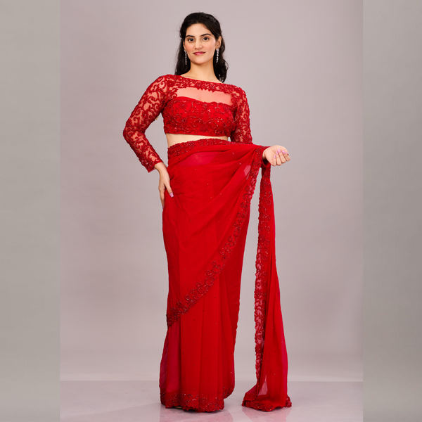 A striking red saree with a scalloped embroidered border, paired with a matching full-sleeve lace blouse.