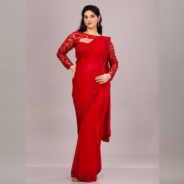 A striking red saree with a scalloped embroidered border, paired with a matching full-sleeve lace blouse.