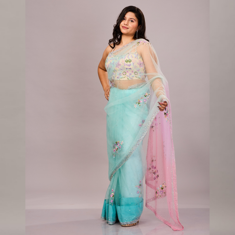 A pastel blue and pink net saree with delicate floral embroidery, paired with a matching embroidered blouse.