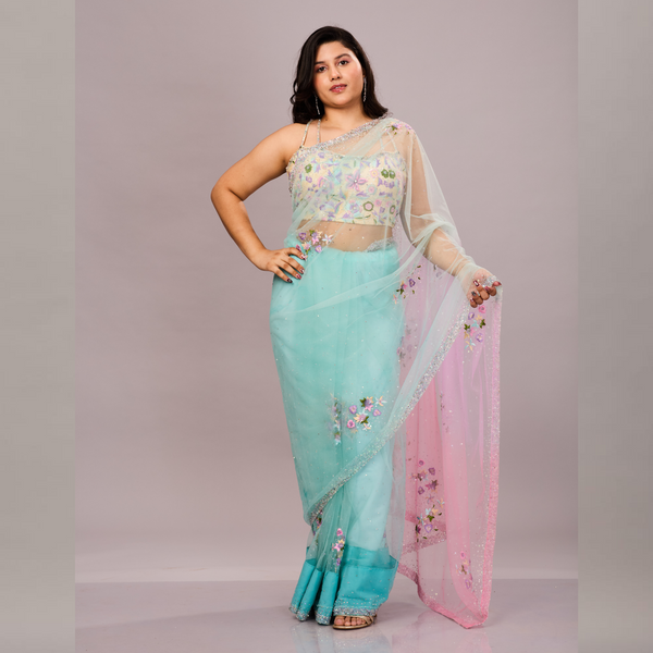 A pastel blue and pink net saree with delicate floral embroidery, paired with a matching embroidered blouse.