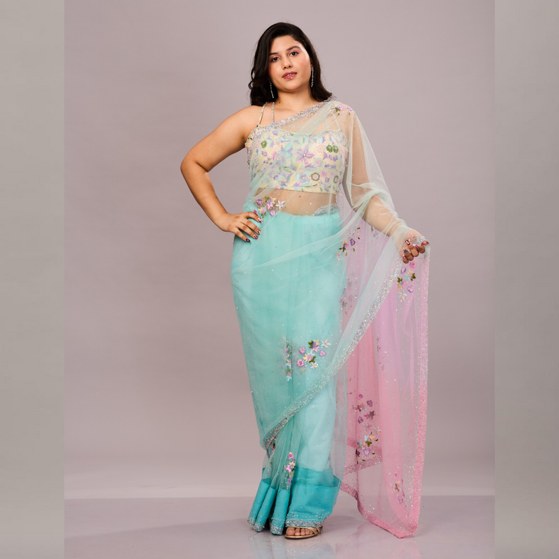 A pastel blue and pink net saree with delicate floral embroidery, paired with a matching embroidered blouse.