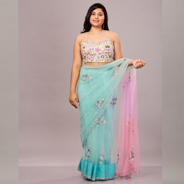 A pastel blue and pink net saree with delicate floral embroidery, paired with a matching embroidered blouse.