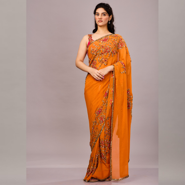 orange saree adorned with intricate floral embroidery and sequin detailing.