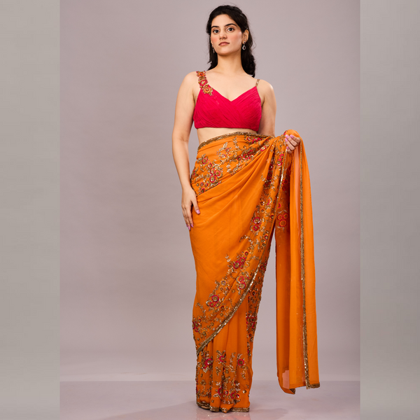 orange saree adorned with intricate floral embroidery and sequin detailing.