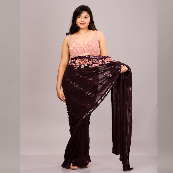 A deep maroon saree with sequin detailing and a pink floral embroidered blouse