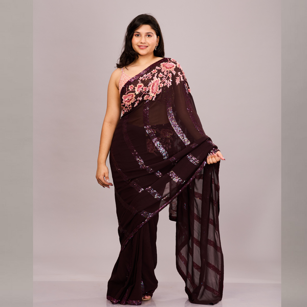 A deep maroon saree with sequin detailing and a pink floral embroidered blouse
