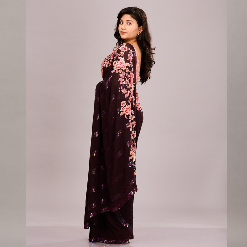 A deep maroon saree with sequin detailing and a pink floral embroidered blouse