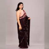 A deep maroon saree with sequin detailing and a pink floral embroidered blouse