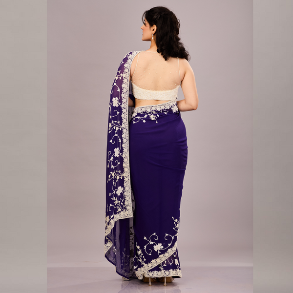 A georgette saree adorned with intricate white floral embroidery along the border and pallu